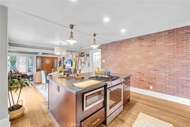 524 Walnut Ave, Long Beach, CA 90802 - kitchen featuring stainless steel gas range oven, light wood-type flooring, a center island, baseboards, and brick wall