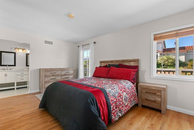 10954 Cool Lake Ter, San Diego, CA 92128 - bedroom with wood finished floors, visible vents, a sink, ensuite bath, and baseboards
