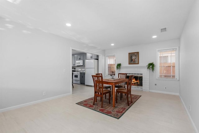 10954 Cool Lake Ter, San Diego, CA 92128 - dining room with baseboards, a fireplace, visible vents, and a wealth of natural light
