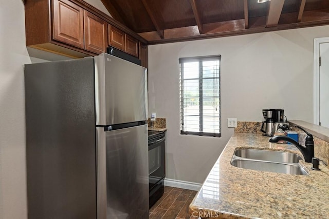 kitchen featuring a sink, dark wood-style flooring, baseboards, freestanding refrigerator, and wood ceiling