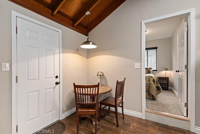 dining area with dark wood finished floors, vaulted ceiling with beams, and baseboards