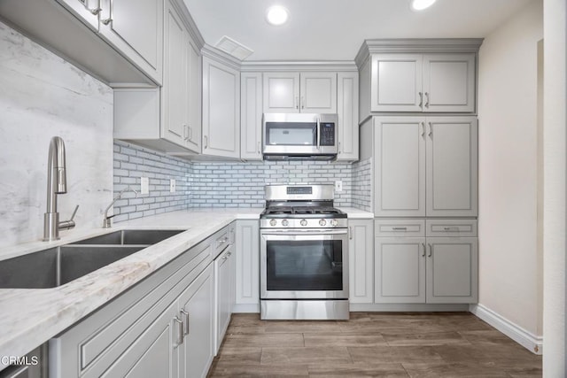 10508 Sunland Blvd Unit 4, Sunland, CA 91040 - kitchen with light stone counters, a sink, backsplash, and appliances with stainless steel finishes