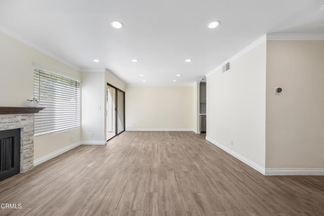 10508 Sunland Blvd Unit 4, Sunland, CA 91040 - unfurnished living room with baseboards, visible vents, light wood-style floors, a stone fireplace, and ornamental molding