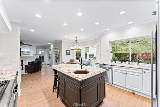kitchen with a sink, appliances with stainless steel finishes, decorative backsplash, and open floor plan