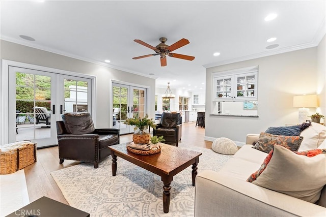 living area featuring ornamental molding, a ceiling fan, french doors, and light wood-style flooring