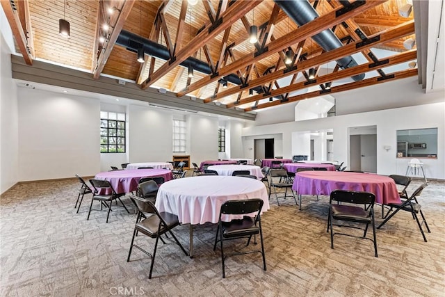 dining area featuring wooden ceiling, high vaulted ceiling, baseboards, and light carpet