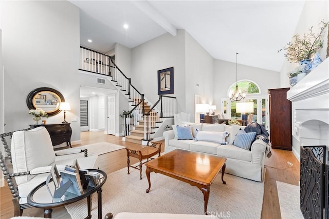 living room with an inviting chandelier, light wood finished floors, high vaulted ceiling, beamed ceiling, and stairway