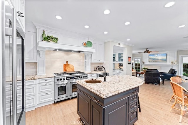 kitchen with light wood-type flooring, white cabinets, and premium appliances