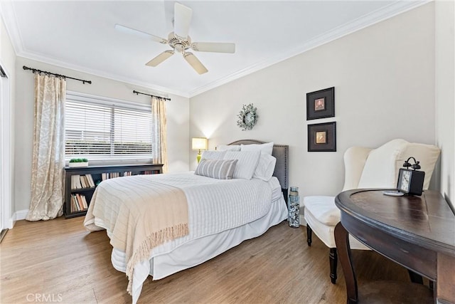 bedroom with ornamental molding, a ceiling fan, and light wood-style flooring