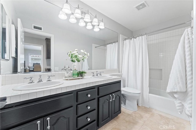 bathroom featuring visible vents, a sink, double vanity, and toilet