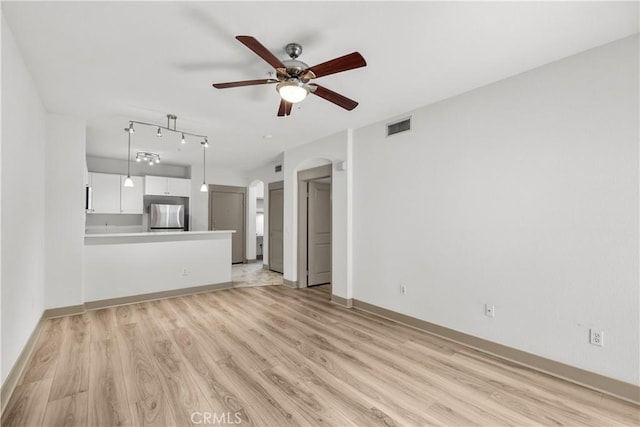 24535 Town Center Dr Unit 6309, Valencia, CA 91355 - unfurnished living room featuring ceiling fan, arched walkways, light wood finished floors, and baseboards