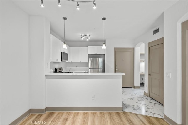 24535 Town Center Dr Unit 6309, Valencia, CA 91355 - kitchen featuring stainless steel appliances, white cabinets, arched walkways, light countertops, and a peninsula