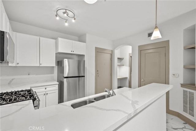 24535 Town Center Dr Unit 6309, Valencia, CA 91355 - kitchen with stainless steel appliances, a sink, light stone countertops, light marble finish floors, and arched walkways