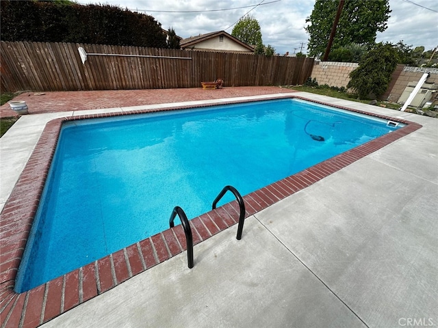 view of swimming pool featuring a fenced backyard, a fenced in pool, and a patio area