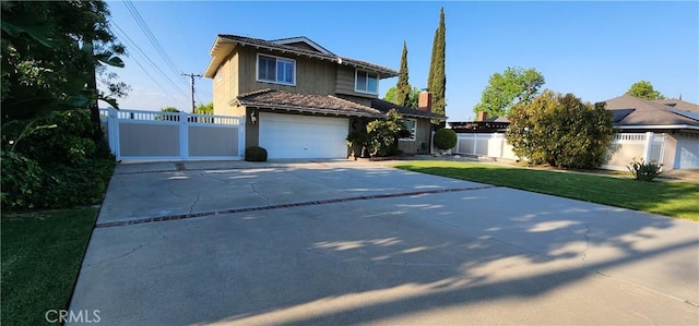 traditional home with fence, driveway, a front lawn, and a garage