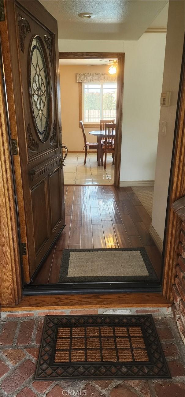 corridor featuring baseboards and a textured ceiling
