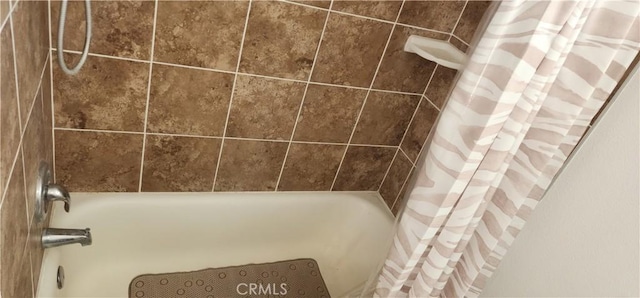 interior details featuring shower / bathtub combination with curtain