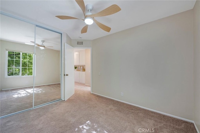unfurnished bedroom with visible vents, a closet, baseboards, ceiling fan, and carpet flooring