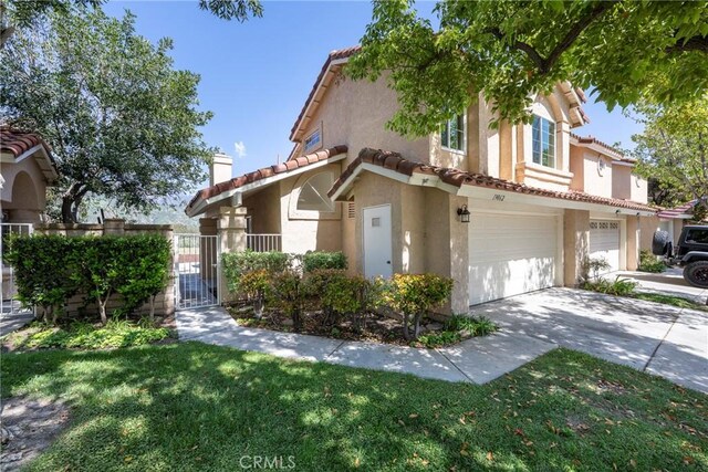 view of front facade featuring a garage, stucco siding, a chimney, a tiled roof, and driveway