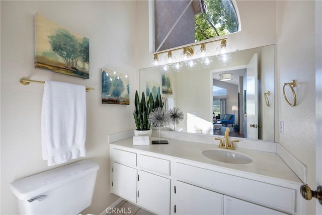 ensuite bathroom with vanity, ensuite bath, and toilet