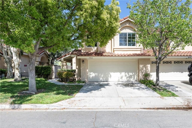 view of front of house featuring a tile roof, a front lawn, concrete driveway, an attached garage, and stucco siding