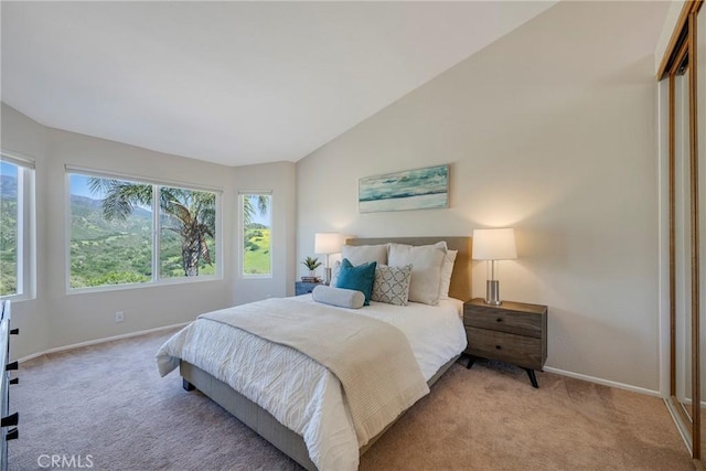 bedroom featuring baseboards, light colored carpet, and vaulted ceiling