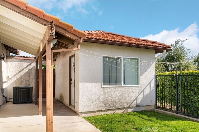 22975 Flournoy Ave, Corning, CA 96021 - view of home's exterior with fence, a tiled roof, cooling unit, and stucco siding