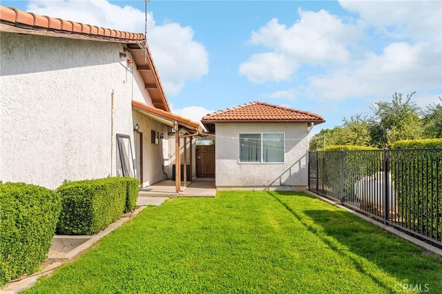 22975 Flournoy Ave, Corning, CA 96021 - back of property with a tile roof, a fenced backyard, a yard, and stucco siding