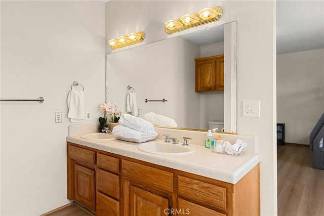 22975 Flournoy Ave, Corning, CA 96021 - full bathroom with toilet, wood finished floors, a sink, and double vanity
