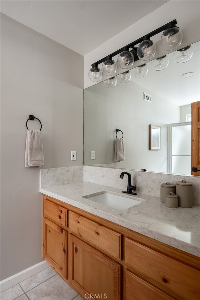 bathroom with a shower with shower door, visible vents, tile patterned flooring, and vanity