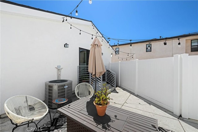 view of patio featuring cooling unit and fence