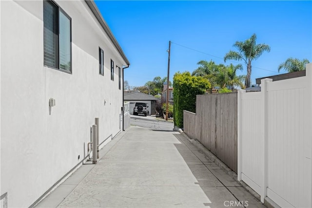 view of side of property with stucco siding and fence