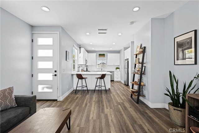 living area with visible vents, baseboards, recessed lighting, and dark wood-type flooring