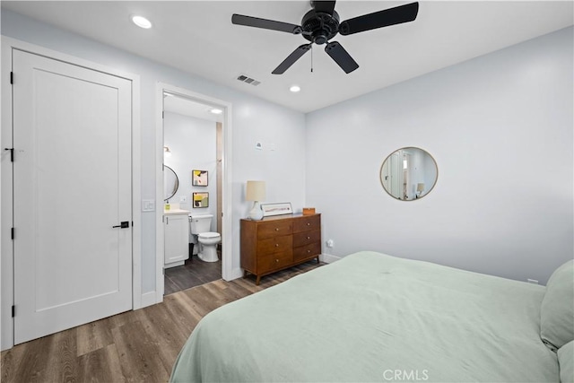 bedroom featuring ensuite bath, wood finished floors, visible vents, and recessed lighting