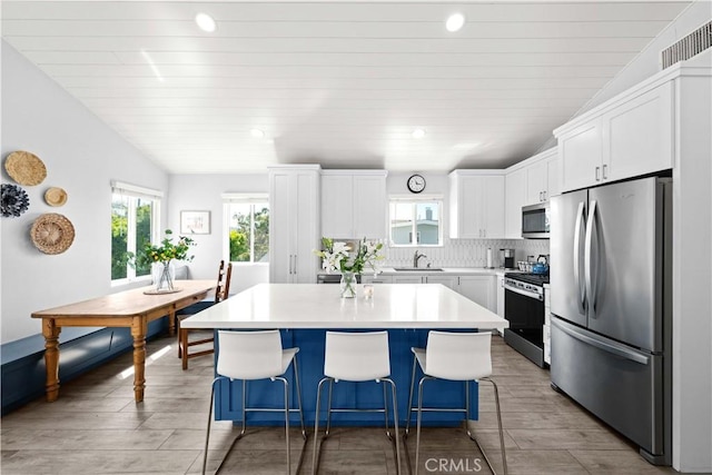 kitchen with visible vents, a healthy amount of sunlight, stainless steel appliances, and a sink