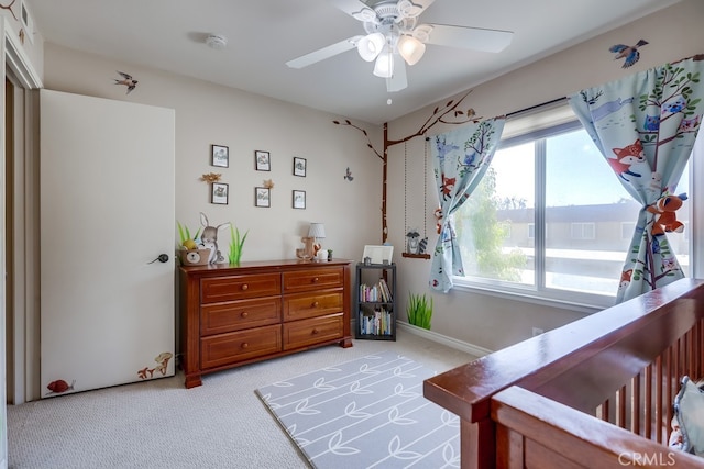 bedroom featuring baseboards, ceiling fan, multiple windows, and light colored carpet