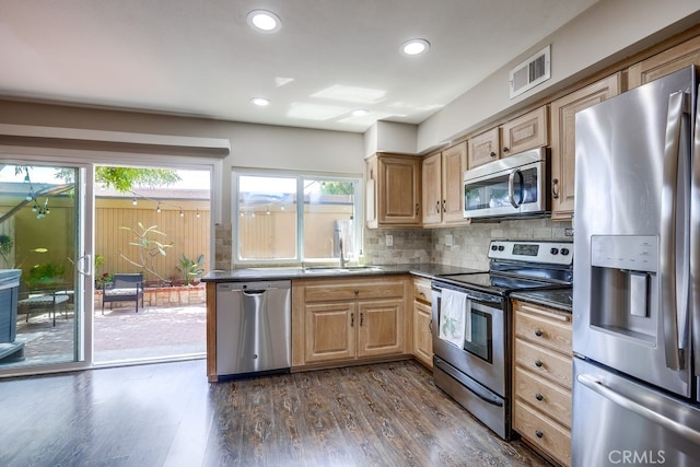 kitchen featuring decorative backsplash, dark countertops, visible vents, stainless steel appliances, and dark wood-type flooring
