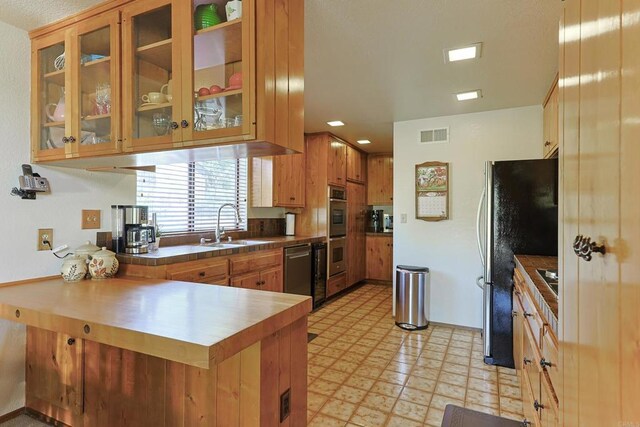 8551 Foothill Blvd, Pine Valley, CA 91962 - kitchen featuring appliances with stainless steel finishes, light flooring, a peninsula, a sink, and glass insert cabinets