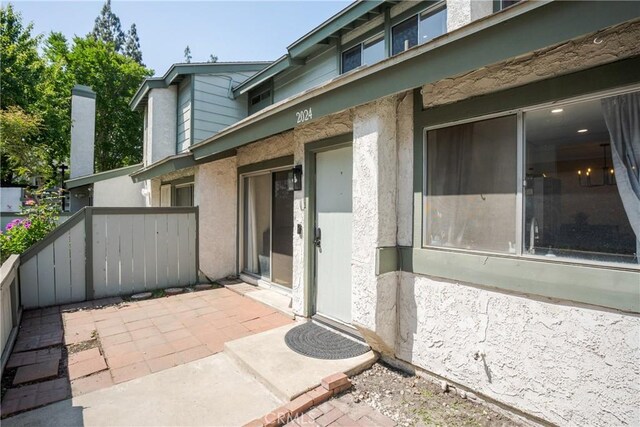 entrance to property featuring a patio and stucco siding