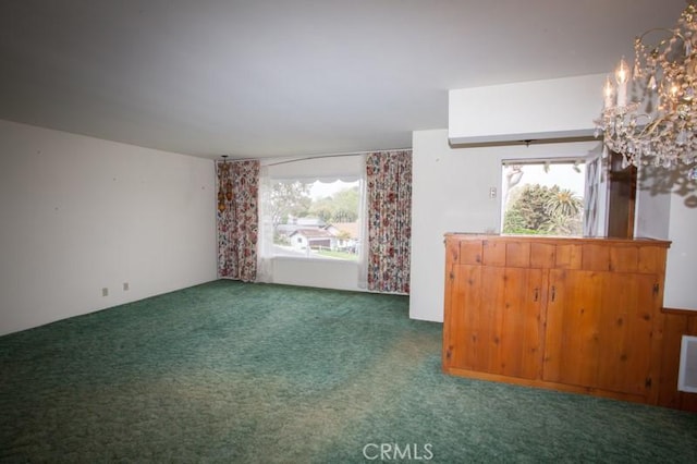spare room with carpet flooring and an inviting chandelier