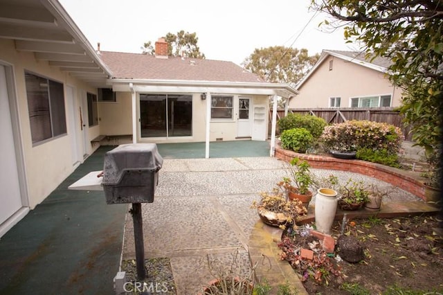 back of property featuring a chimney, fence, and a patio area
