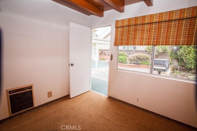 spare room with carpet floors and beam ceiling