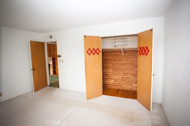 unfurnished bedroom with carpet floors and a closet