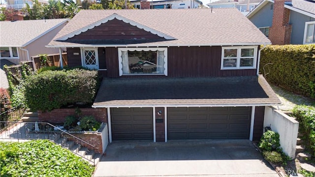 craftsman house featuring stairway, driveway, roof with shingles, and a garage