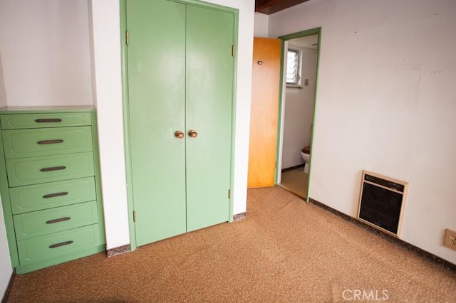 unfurnished bedroom featuring light carpet, heating unit, and a closet