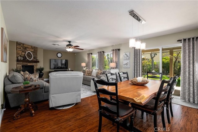 33077 Monte Dr, Temecula, CA 92592 - dining area with dark wood-style flooring, a stone fireplace, plenty of natural light, and a ceiling fan