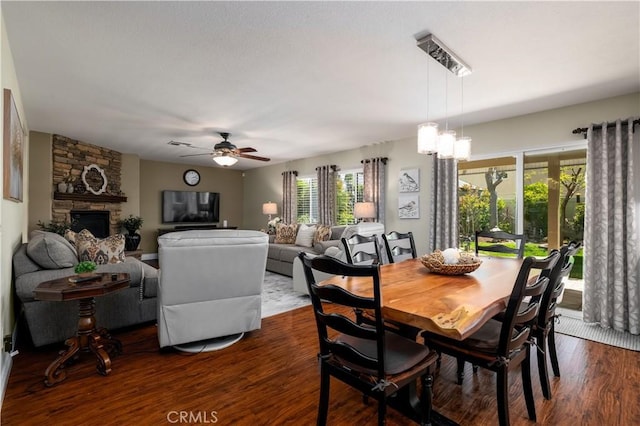33077 Monte Dr, Temecula, CA 92592 - dining space with healthy amount of natural light, dark wood finished floors, a stone fireplace, and a ceiling fan