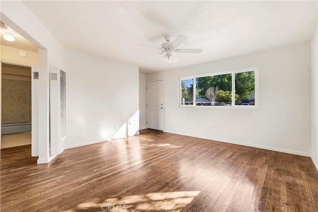 empty room with a heating unit, visible vents, baseboards, hardwood / wood-style flooring, and ceiling fan