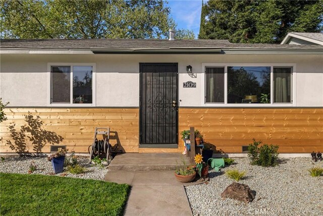 property entrance featuring a shingled roof