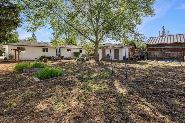exterior space featuring fence, an outbuilding, a garden, and a shed